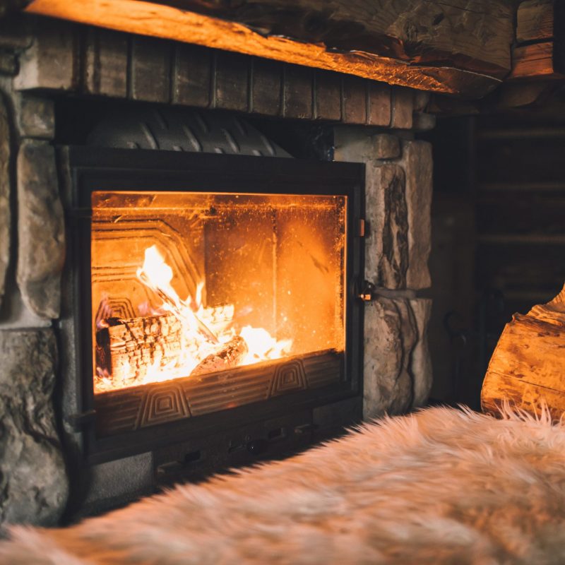 Warm cozy fireplace with real wood burning in it. Cozy winter concept. Christmas and travel background with space for your text.